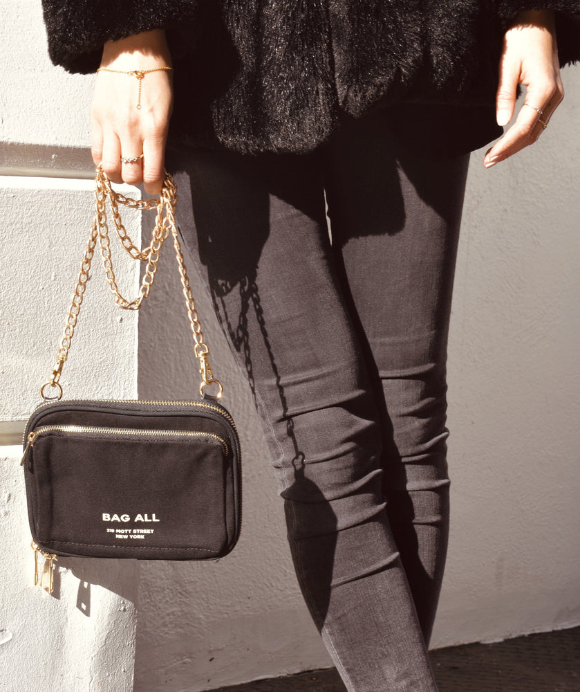 
                                      
                                        Someone holding a bag-all purse with a metal chain. 
                                      
                                    