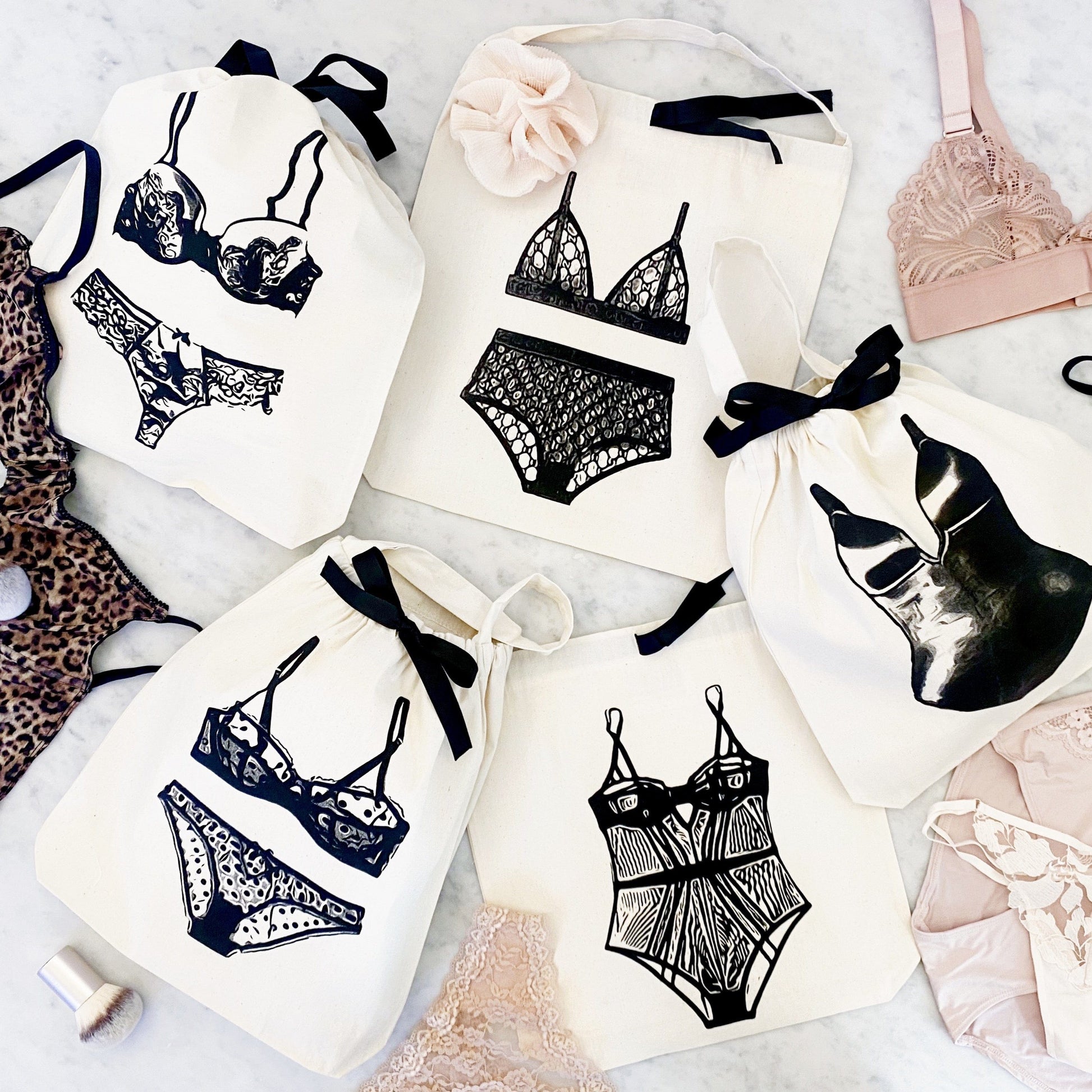 Bag-all Polkadot Lingerie Travel Bag in cream with black ribbon ties featuring stylish lingerie illustrations, perfect for organizing delicates while traveling or at home