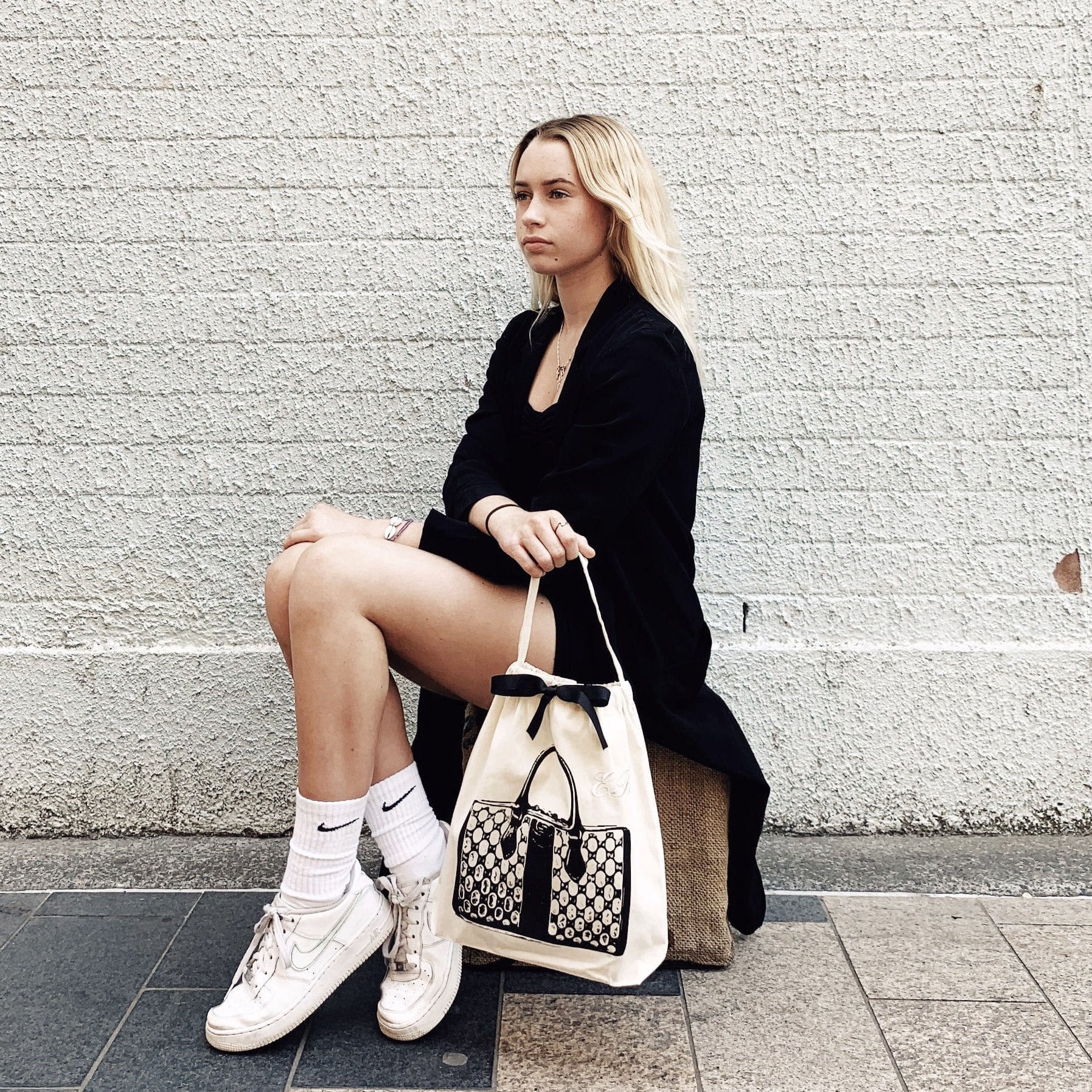 A girl holding her vintage handbag dust bag in her hand. 