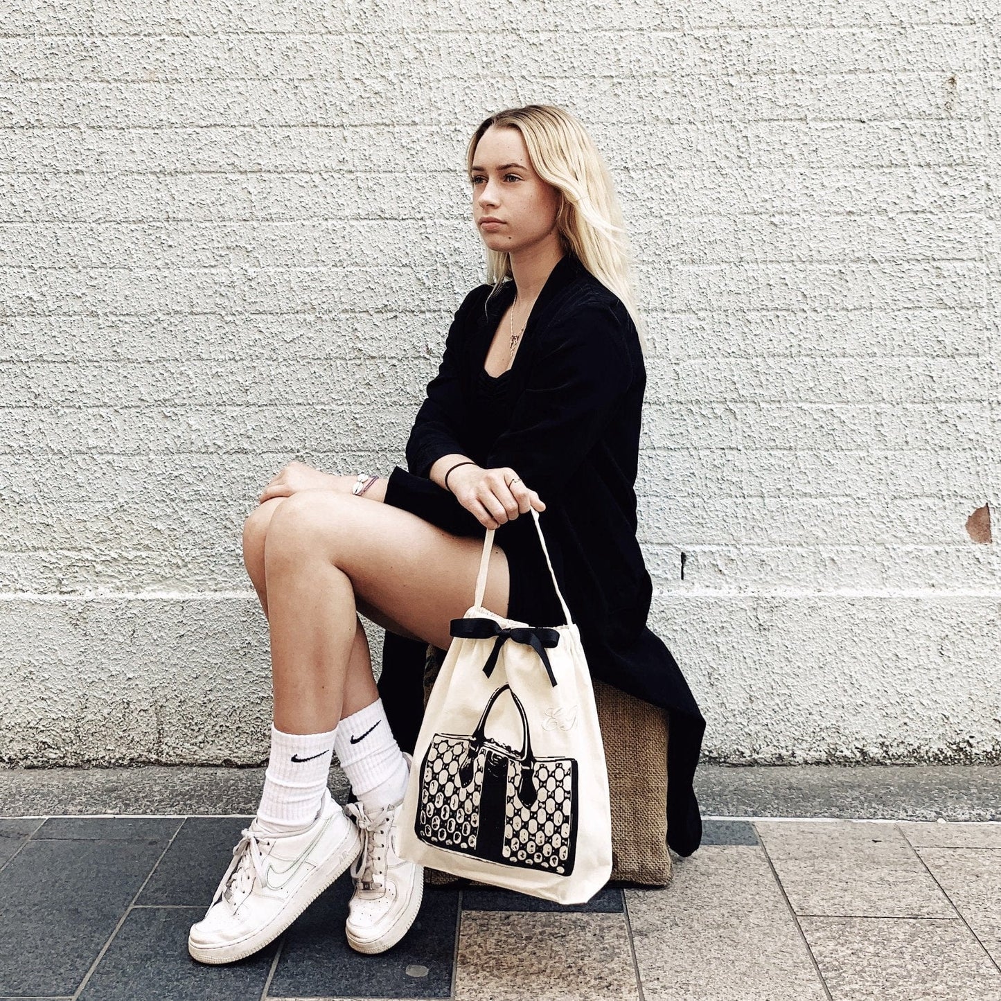 
                                      
                                        A girl holding her vintage handbag dust bag in her hand. 
                                      
                                    