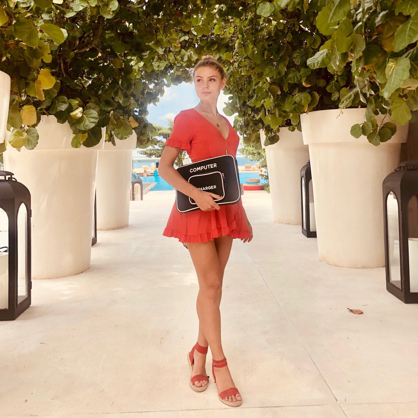 
                                      
                                        A girl in a red dress holding a black laptop sleeve case.
                                      
                                    