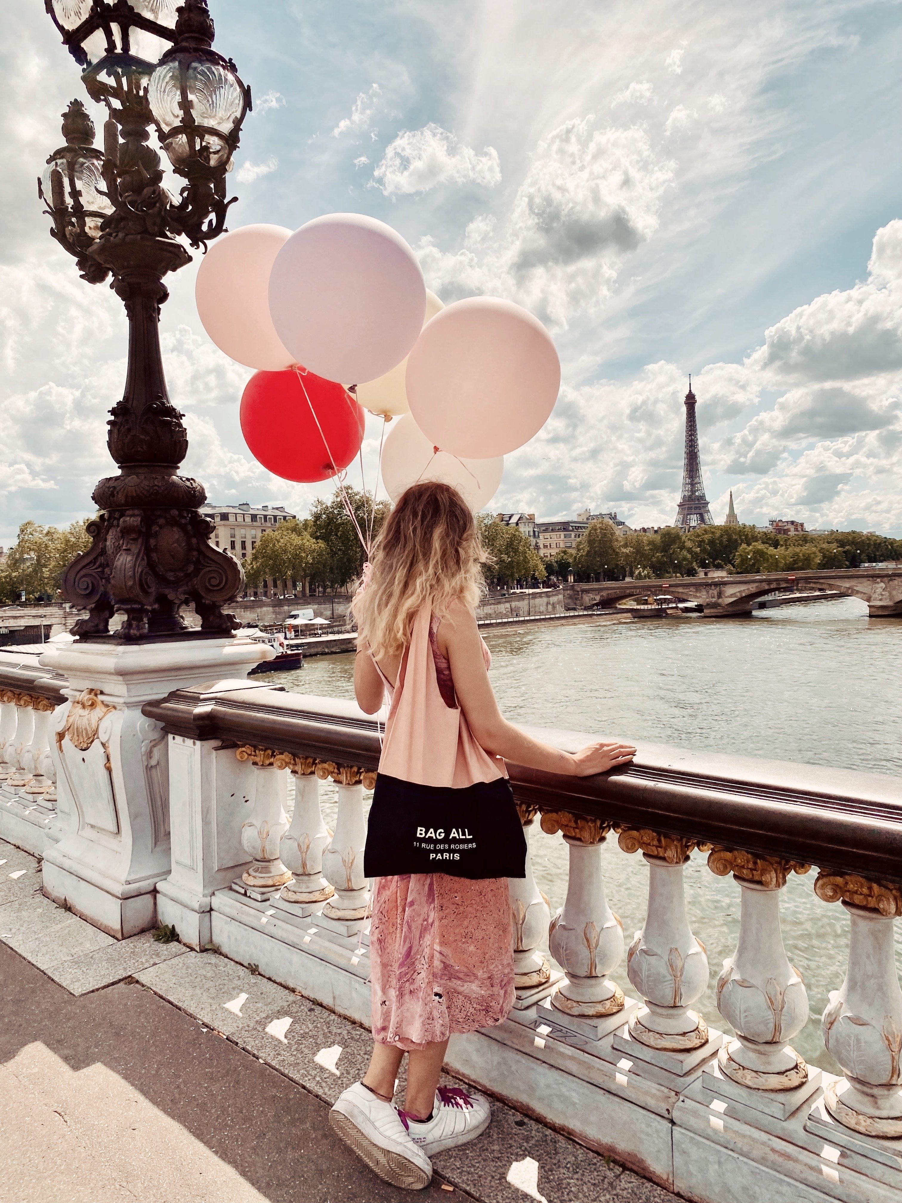 Girl in Paris holding balloons with a bag all tote bag. 