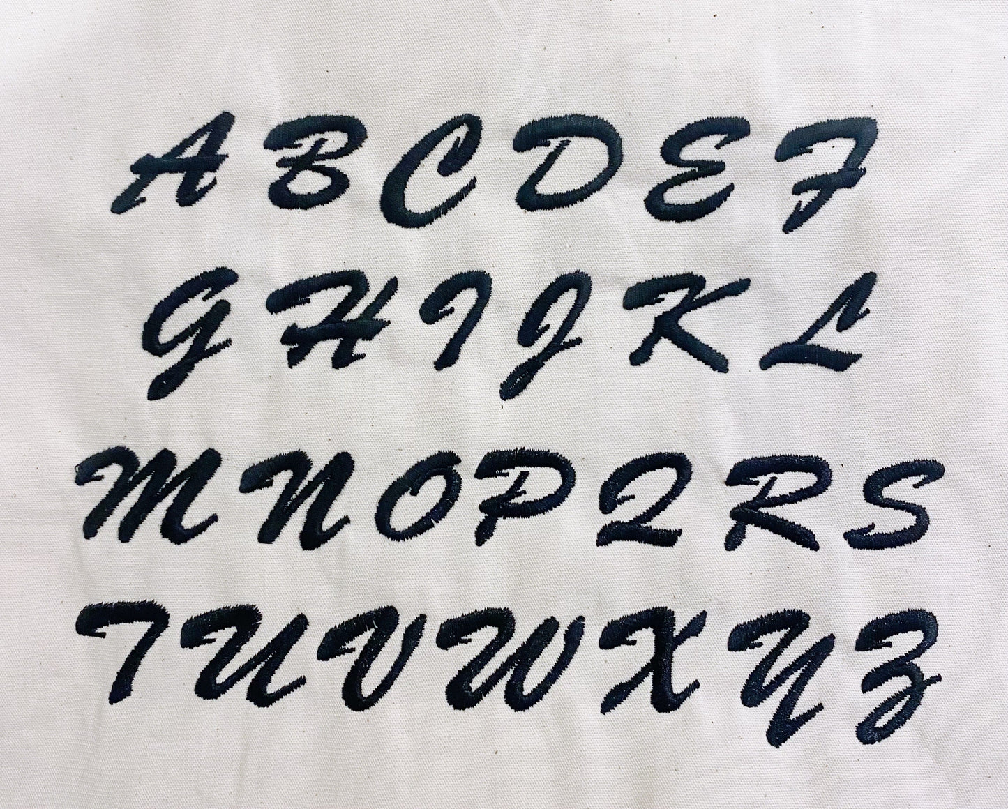 Bag-all monogram font alphabet displayed in cursive style for personalized bag customization. Letters A to Z shown in elegant black script for custom monogramming options.
