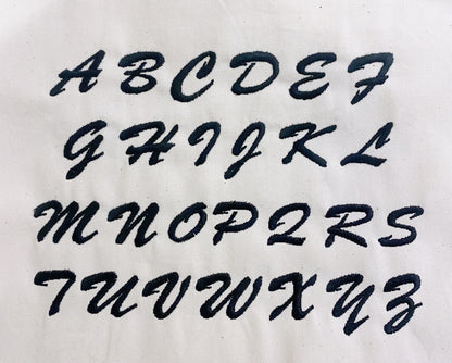 Bag-all monogram font alphabet displayed in cursive style for personalized bag customization. Letters A to Z shown in elegant black script for custom monogramming options.