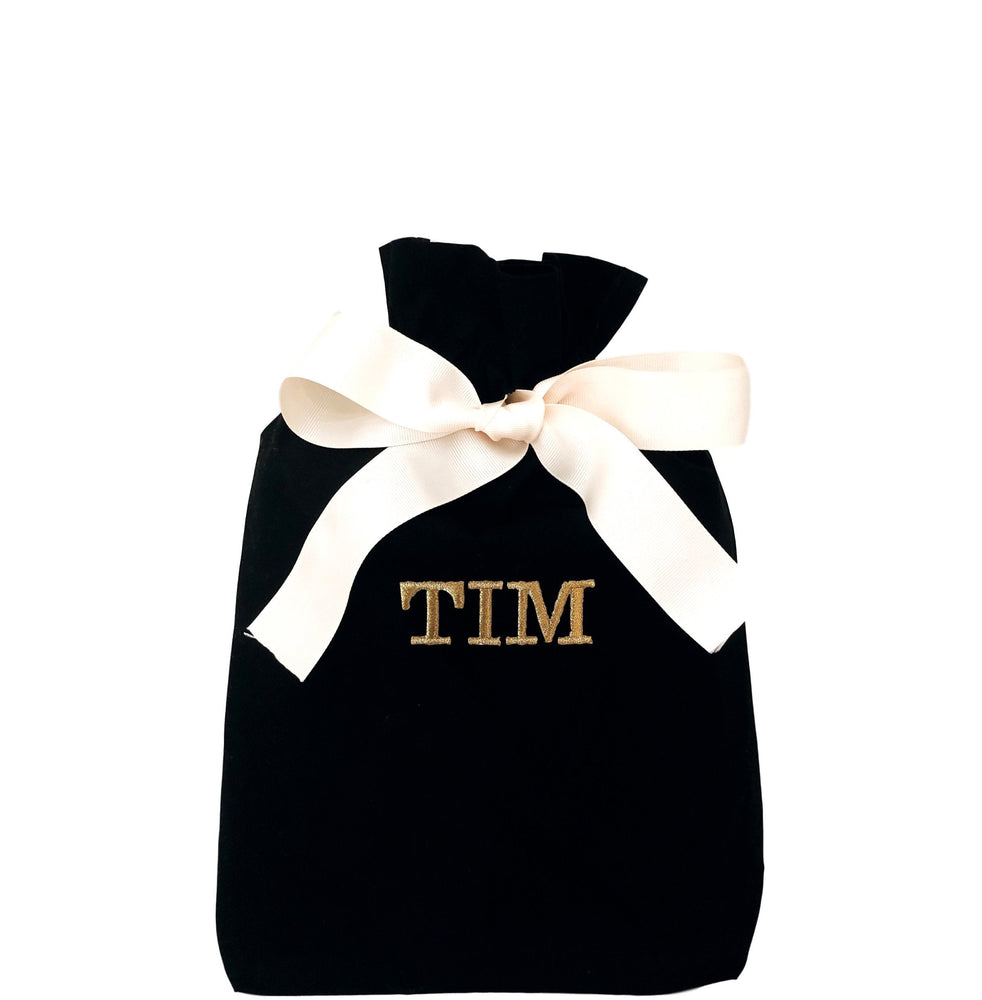 
                                      
                                        A black reusable gift bag with "TIM" printed on the front. 
                                      
                                    