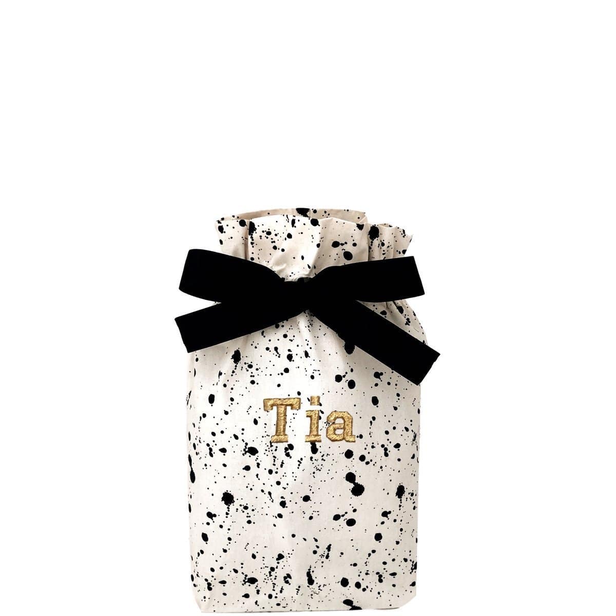 Small gift bag splattered with "Tia" monogrammed on the front. 