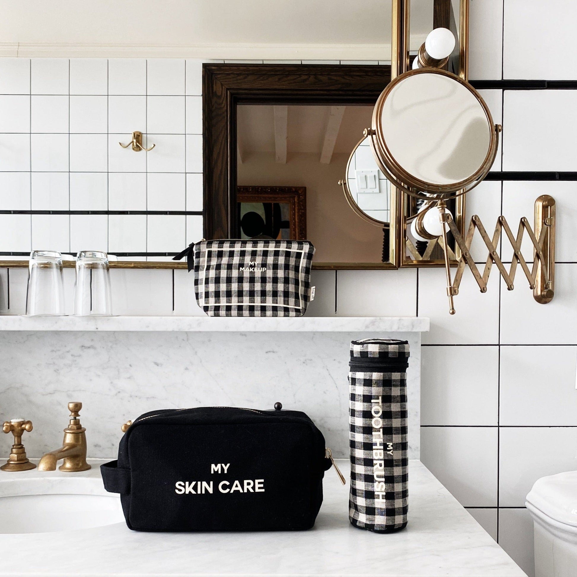 Bag-all Toothbrush Travel Case in stylish black and white gingham pattern, displayed on marble counter with matching bathroom accessories and expandable vanity mirror