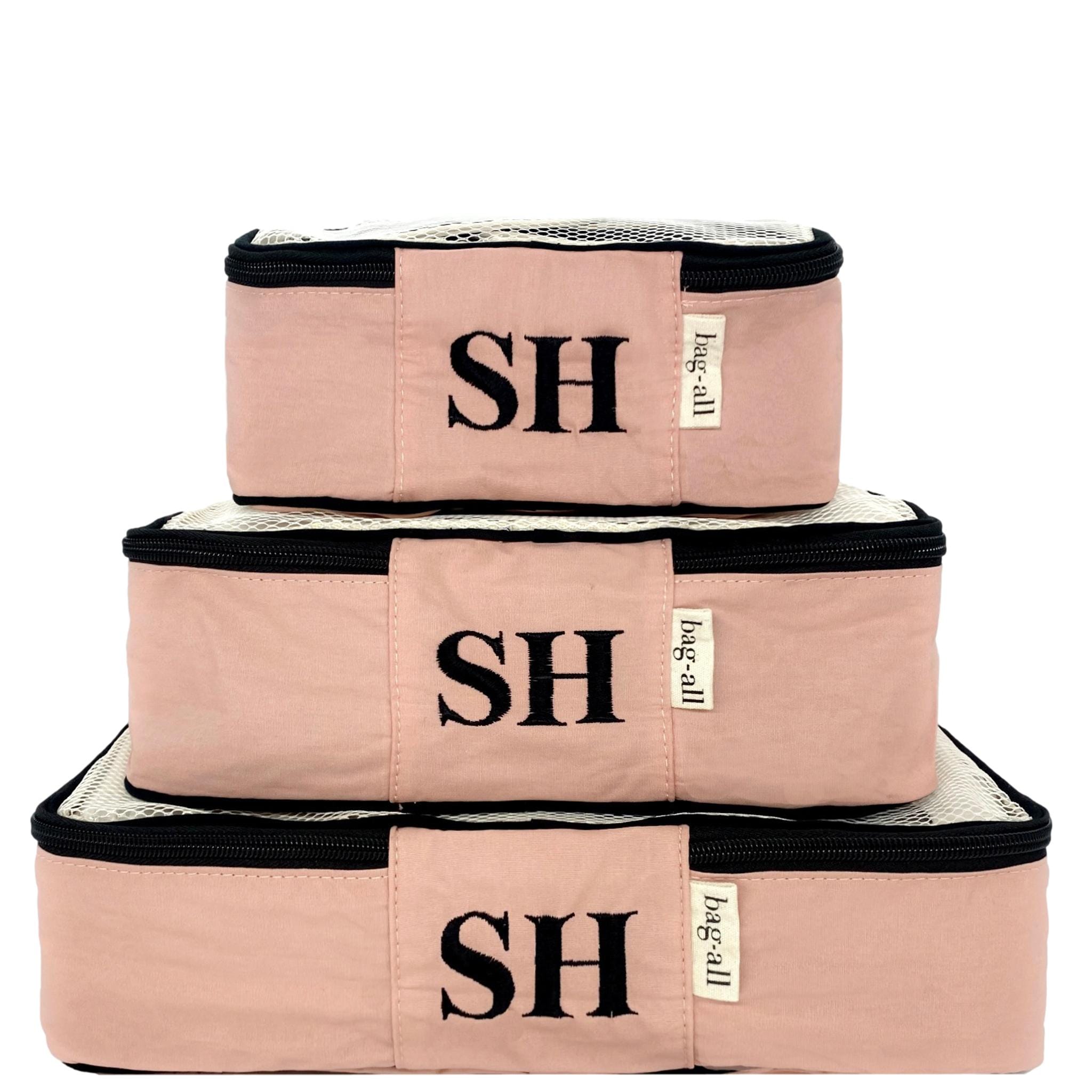 3 pink packing cubes with "SH" monogram.