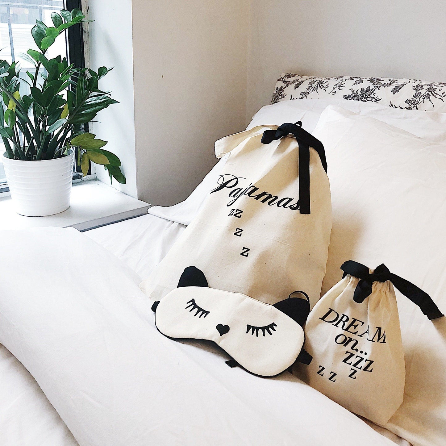 
                                      
                                        Sleeping Mask, Case, pajama zzz bag on bed with zz plant in window
                                      
                                    