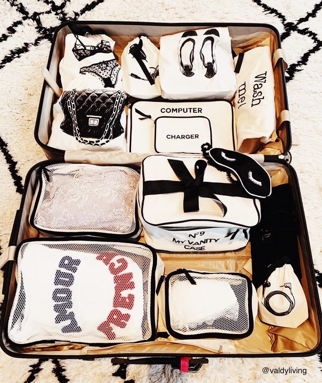 Suitcase filled with personalized packing cubes, charger case, vanity case, laundry bag and more. 